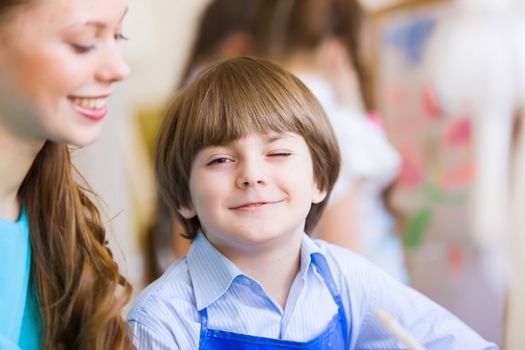 Young teacher and children painting and playing