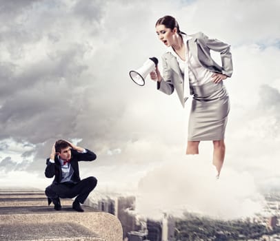 Angry businesswoman with megaphone shouting at colleague