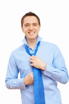 Young businessman at home preparing for a work and making his tie