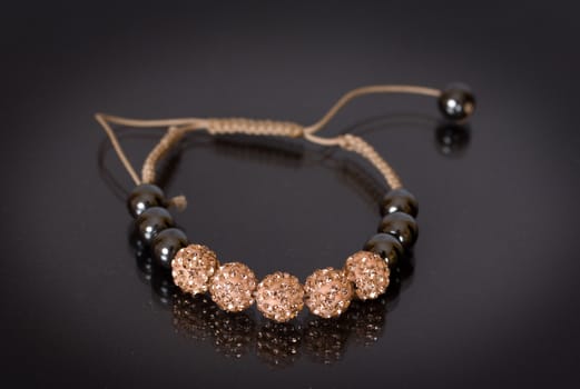 Popular Buddhist bracelet shamballa on a black background