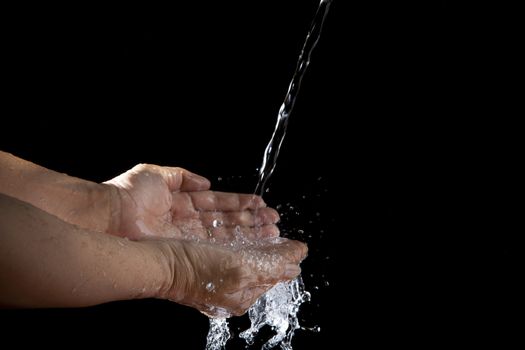 file of hand and pouring water on black background