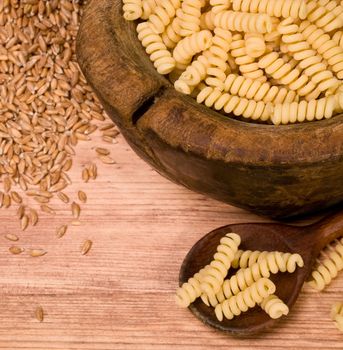 pile of fusilli pasta close up on wood background