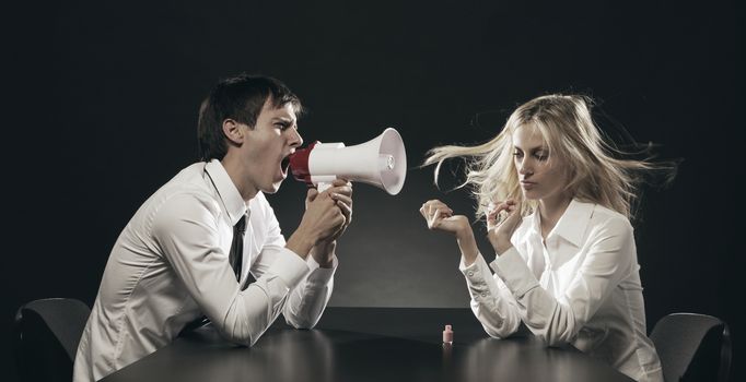 Husband using a megaphone to scream at his wife applying nail polish