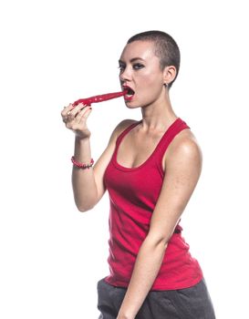 Woman eating chili pepper on white background