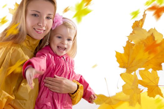 Mother and daughter catching falling leaves, over white