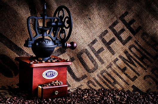 This image is of coffee beans, coffee grinder, and coffee beans bag in background.
