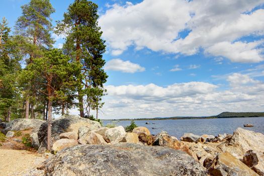 Beautiful landscape with lake shore, stones and pines