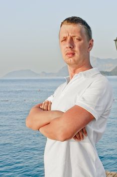 a man with a serious expression on his face is in a closed position against the sea