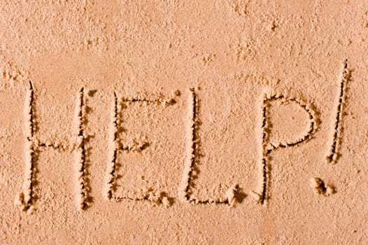 on the wet sand written the word "Help!" by the sea