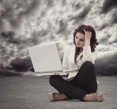 Frustrated Young woman sitting on the floor and  looking at the computer