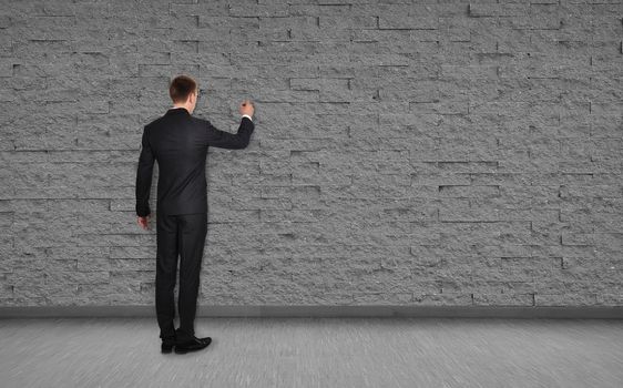 businessman drawing on brick wall