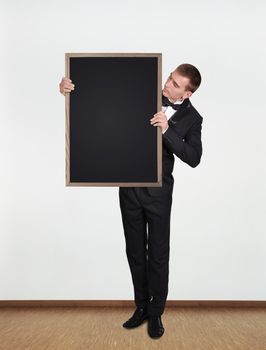 businessman standing in office and  holding blank blackboard