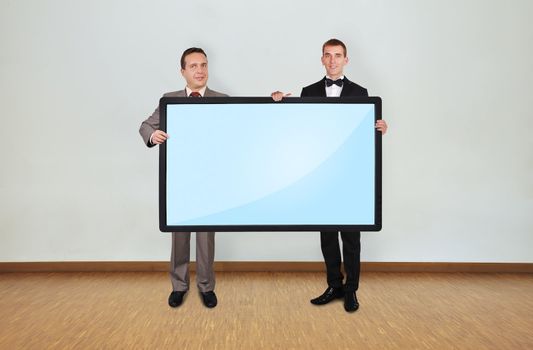 two businessman in room holding blank plasma panel