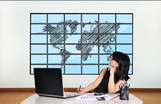 woman in office looking at plasma with world map