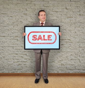 businessman in room holding plasma with sale symbol