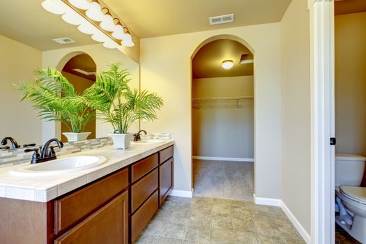 New home bathroom  interior with shower and bath combination, wood cabinet and toilet.