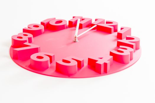 Red clock on isolated white showing five minutes to midnight