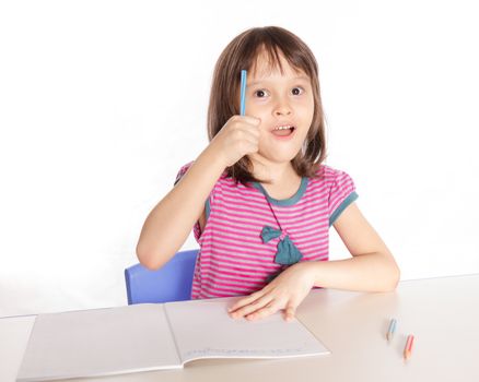 Child at desk with pencils and notebook