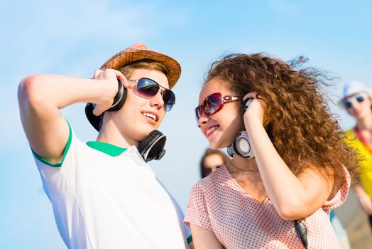 young couple standing on the road, having fun with friends