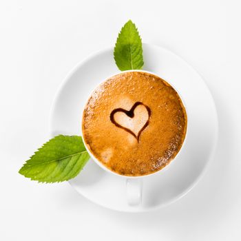 large cup of coffee with heart pattern on the foam and green leaf of mint