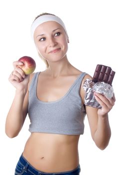 Young woman having a dilemma between fruit and chocolate - isolated over white