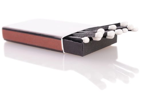 Box with balck matches with reflection over a white background 