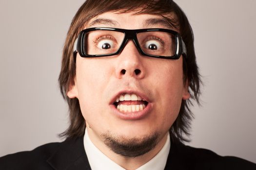 Close-up photo of screaming businessman, on a gray background