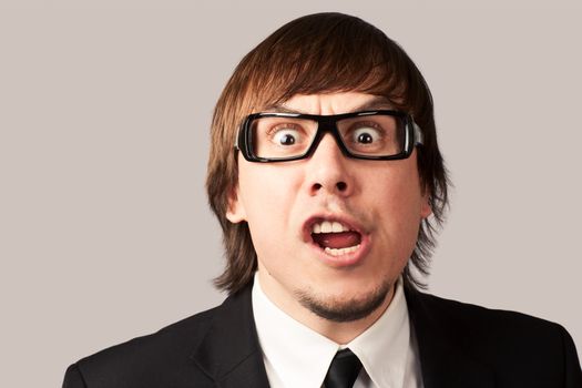 Close-up photo of screaming businessman, on a gray background