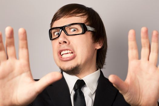 Close-up portrait of businessman, hearing some bad news. On a gray background