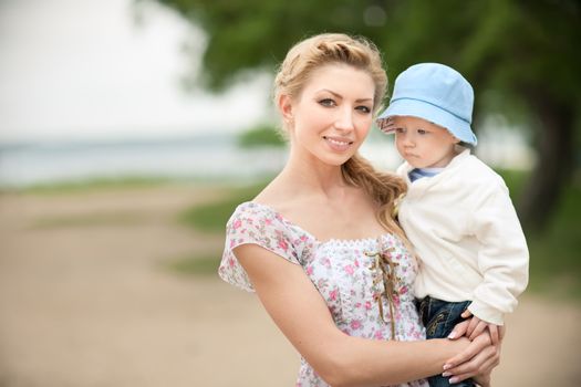 Happy blonde mom and son outdoors