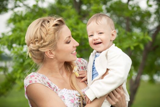 Happy blonde mom and son outdoors