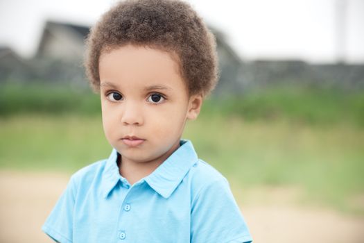 cute african american boy on a background of green grass