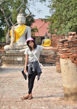 Beautiful young girl and buddha at Wat Yai Chai Mongkol Temple. Ayutthaya - Thailand