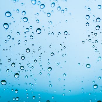 background drops of water on glass blue color