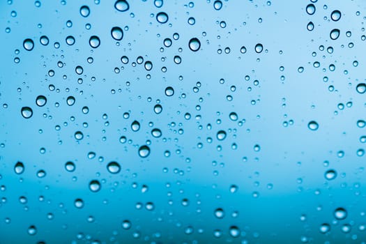 background drops of water on glass blue color