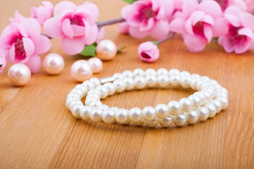 pearl bangles, with pink flower on wooden background