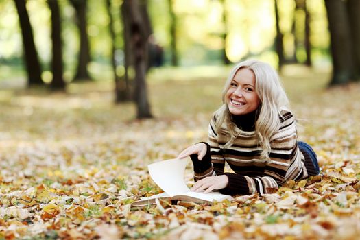 woman read the book in autumn park