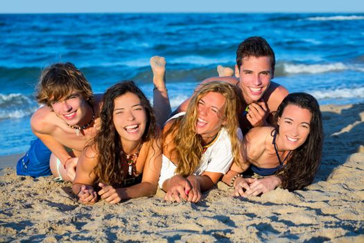 Boys and girls teen group having fun happy on the blue beach sand