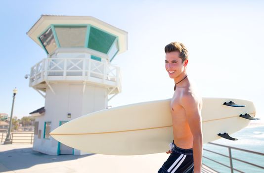Surfer boy teenager with surfboard in Huntington beach pier California