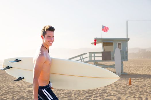 Surfer boy teenager with surfboard in Santa Monica Lifeguard house California