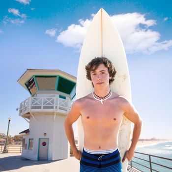 Surfer boy teenager with surfboard in Huntington beach pier California