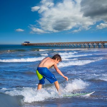 Boy surfer surfing waves on Newport pier beach California