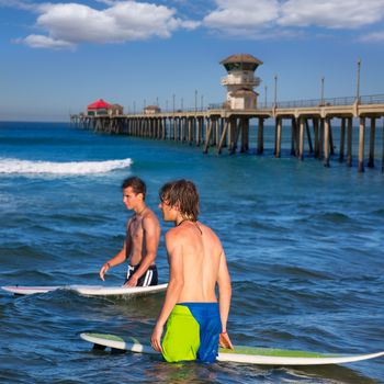 surfers waiting for the waves on Huntington beach pier California