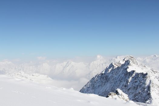 Mountain peaks of winter alps under blue sky