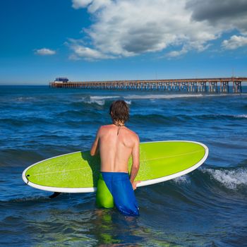 boy surfer waiting for the waves on Newport pier beach California