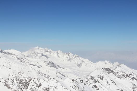 Mountain peaks of winter alps under blue sky