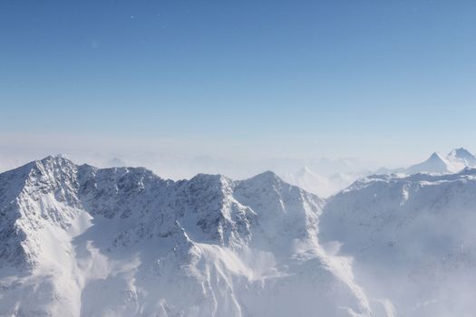 Mountain peaks of winter alps under blue sky