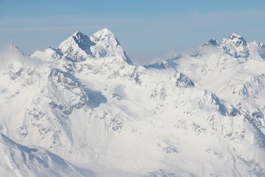 Mountain peaks of winter alps under blue sky