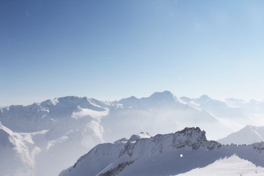 Mountain peaks of winter alps under blue sky