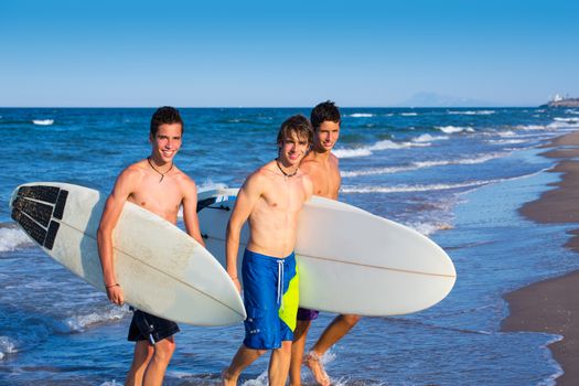 Boys surfers group coming out from blue beach